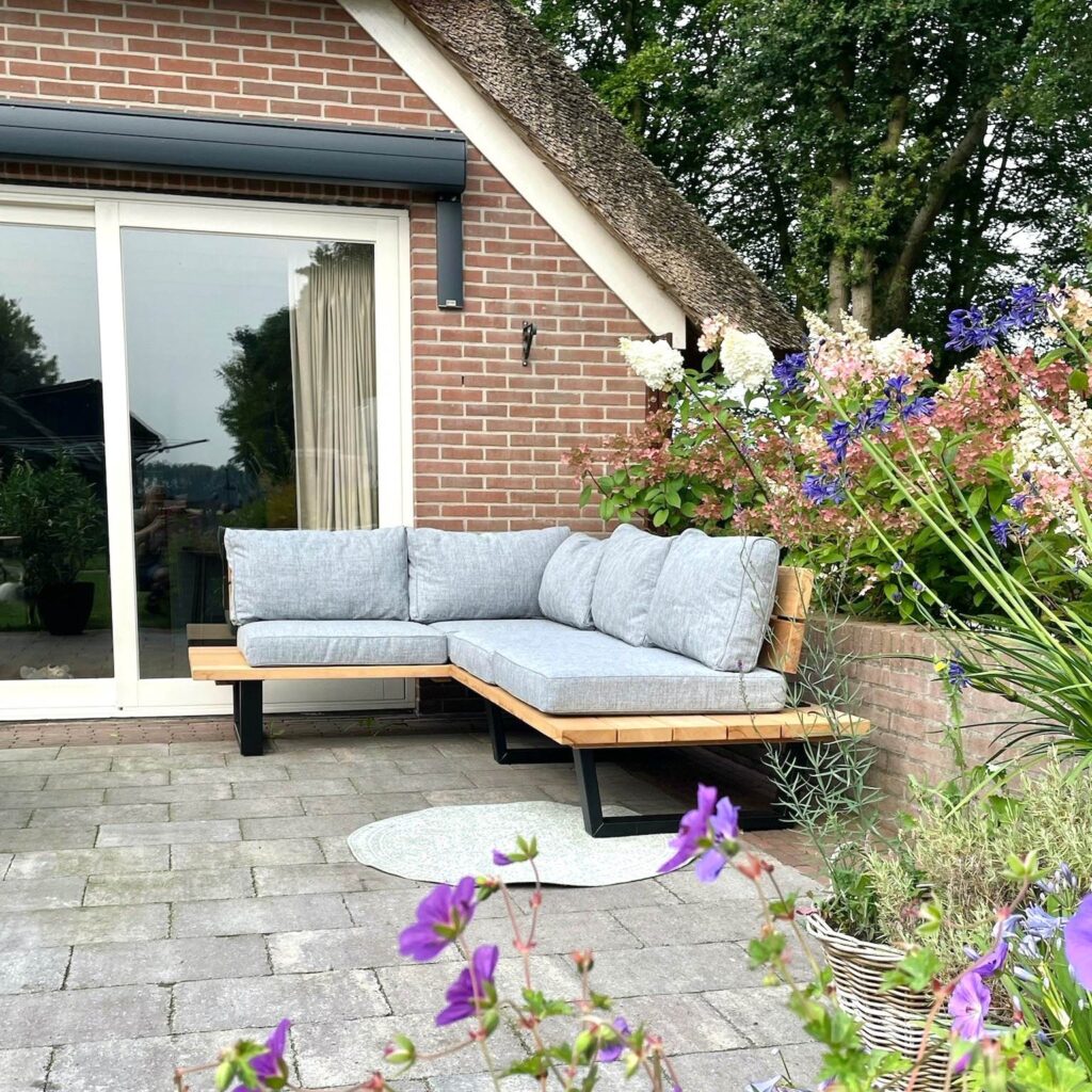 Groene tuin met loungeset van hardhout en bloemen hoekbank voor 4 personen
