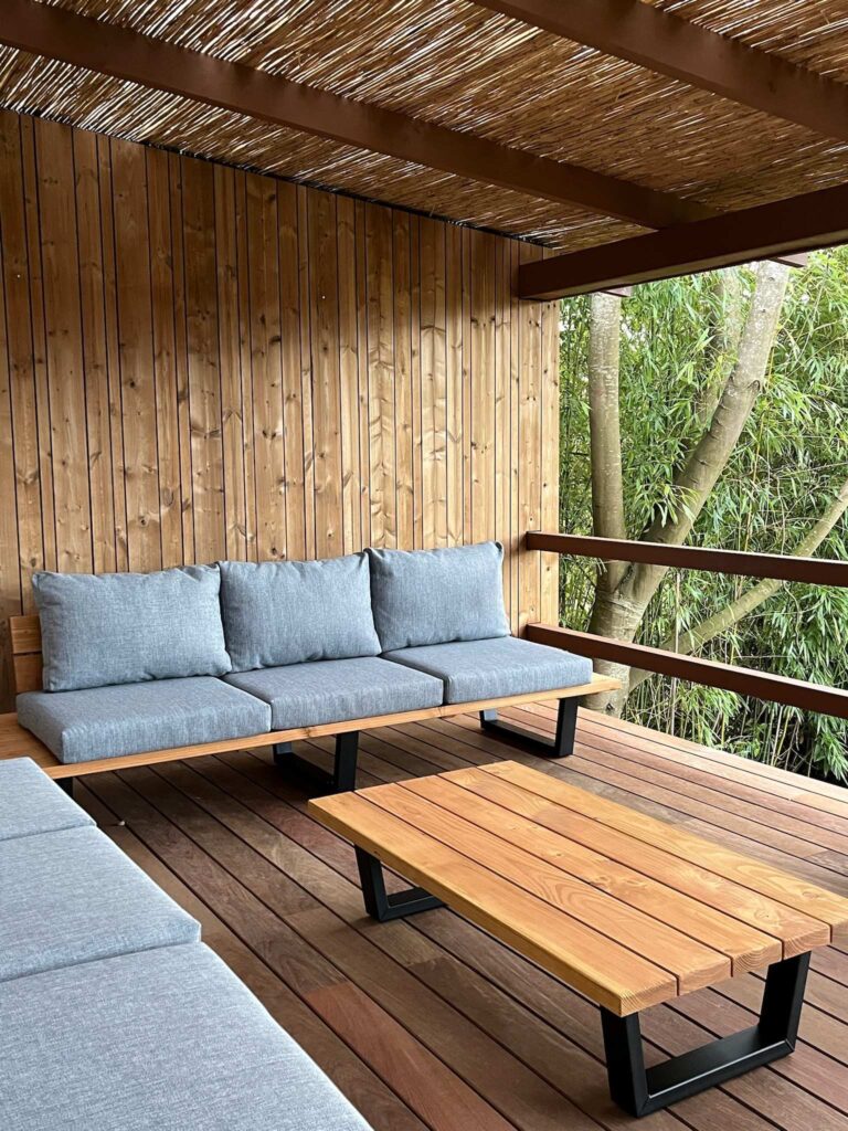 Terras met loungebank en hocker grijze kussens
